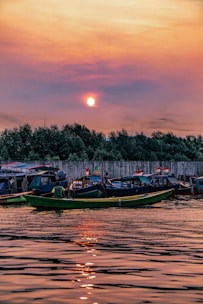 Colorful traditional boats docked at a vibrant Indonesian harbor at sunset.