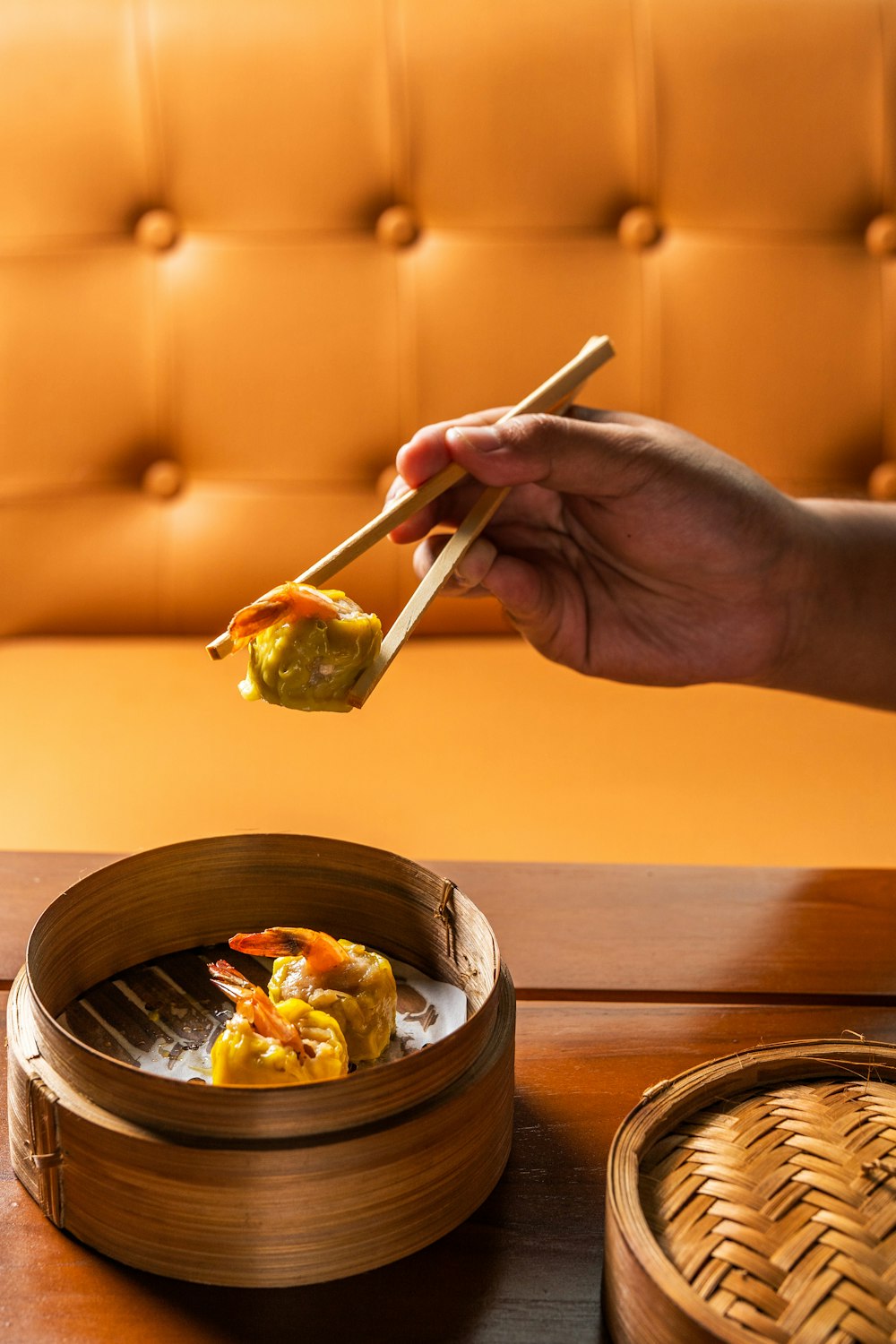 person holding chopsticks with vegetable salad in bowl