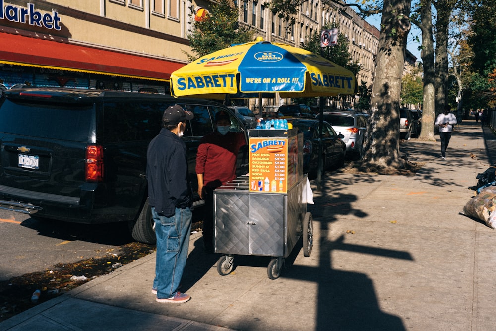people standing near food cart during daytime