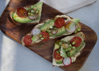 sliced cucumber and tomato on brown wooden chopping board