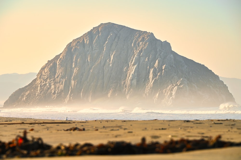 brown and white mountain near body of water during daytime