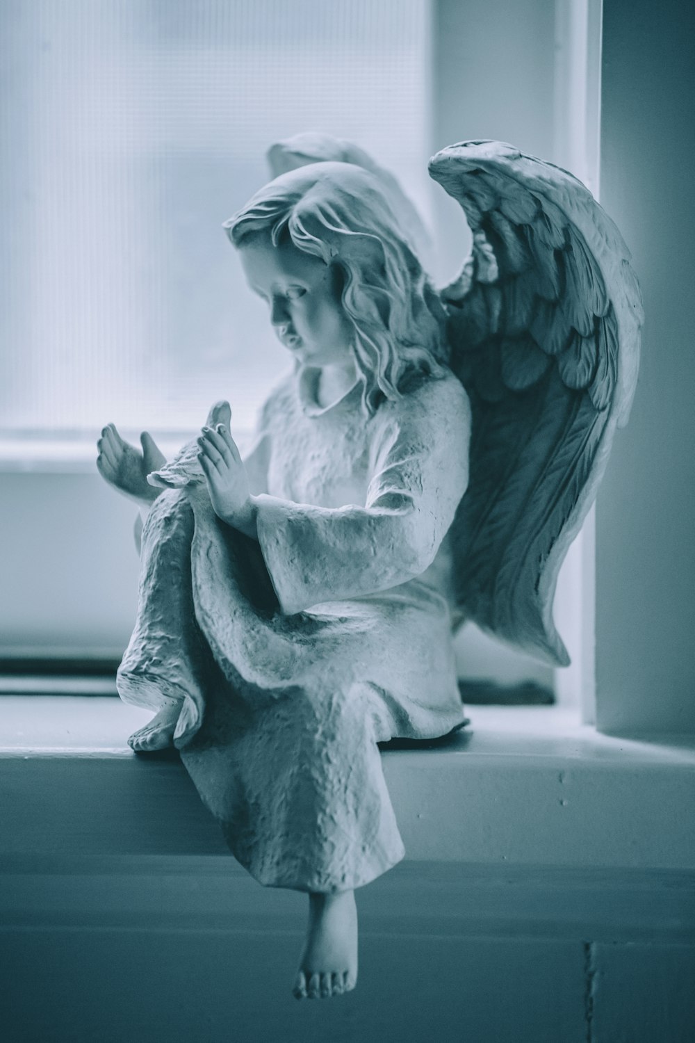 Statuetta in ceramica angelo su tavolo nero