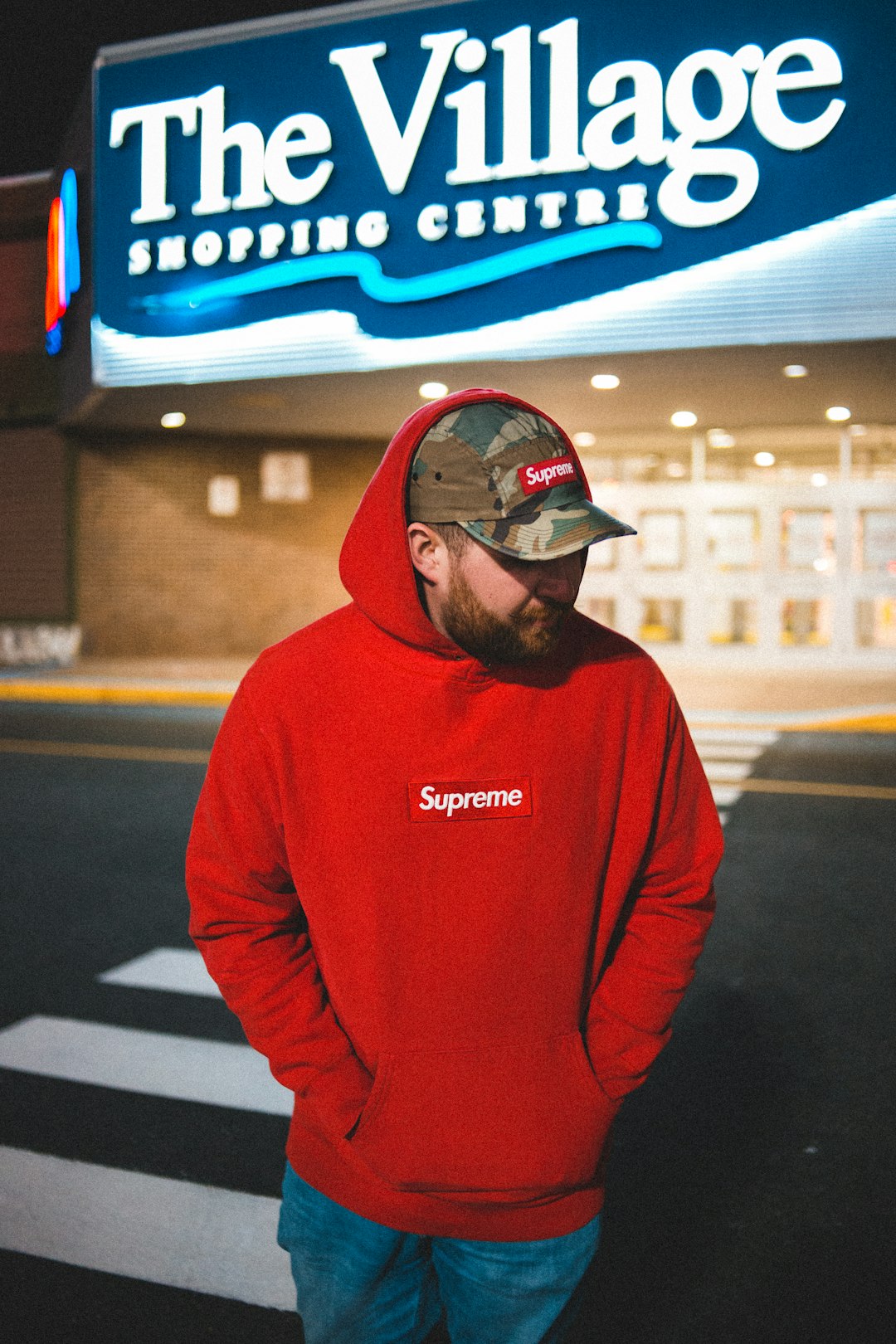 man in red hoodie wearing black and white cap