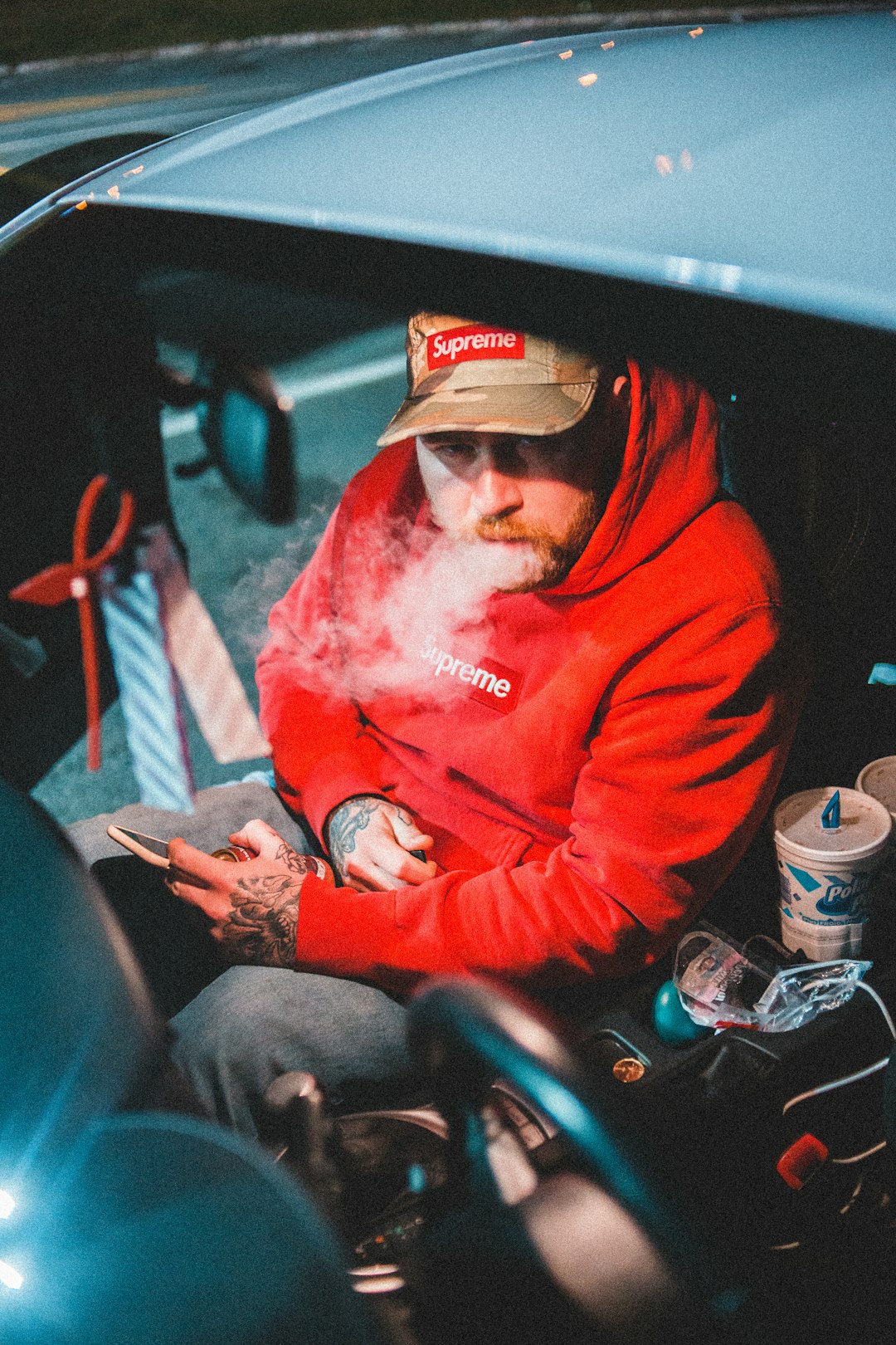 man in red hoodie smoking