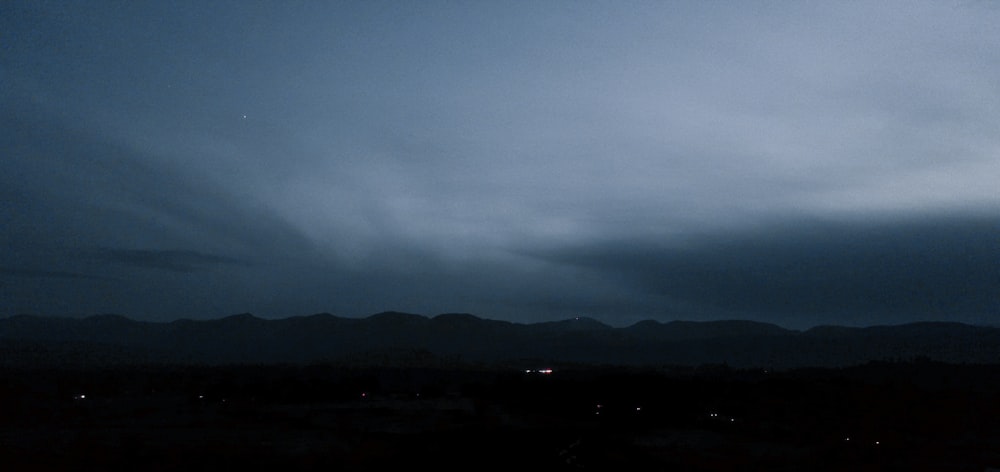 silhouette of mountain under gray clouds