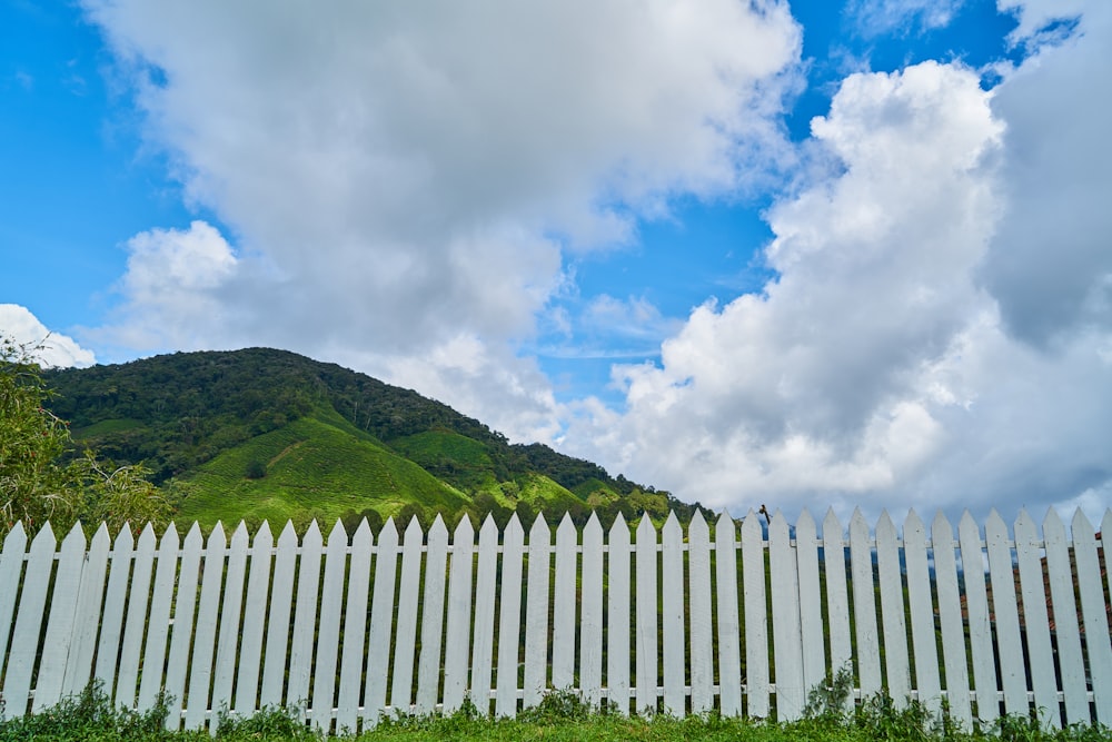 montaña verde bajo nubes blancas y cielo azul durante el día