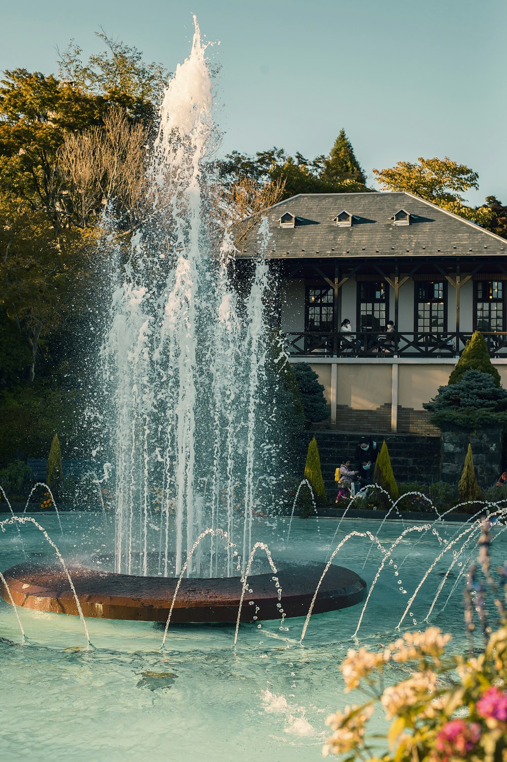 water fountain in front of brown and white house