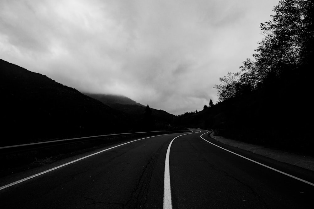 grayscale photo of road near mountain