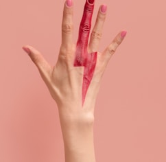 person with pink manicure on pink surface