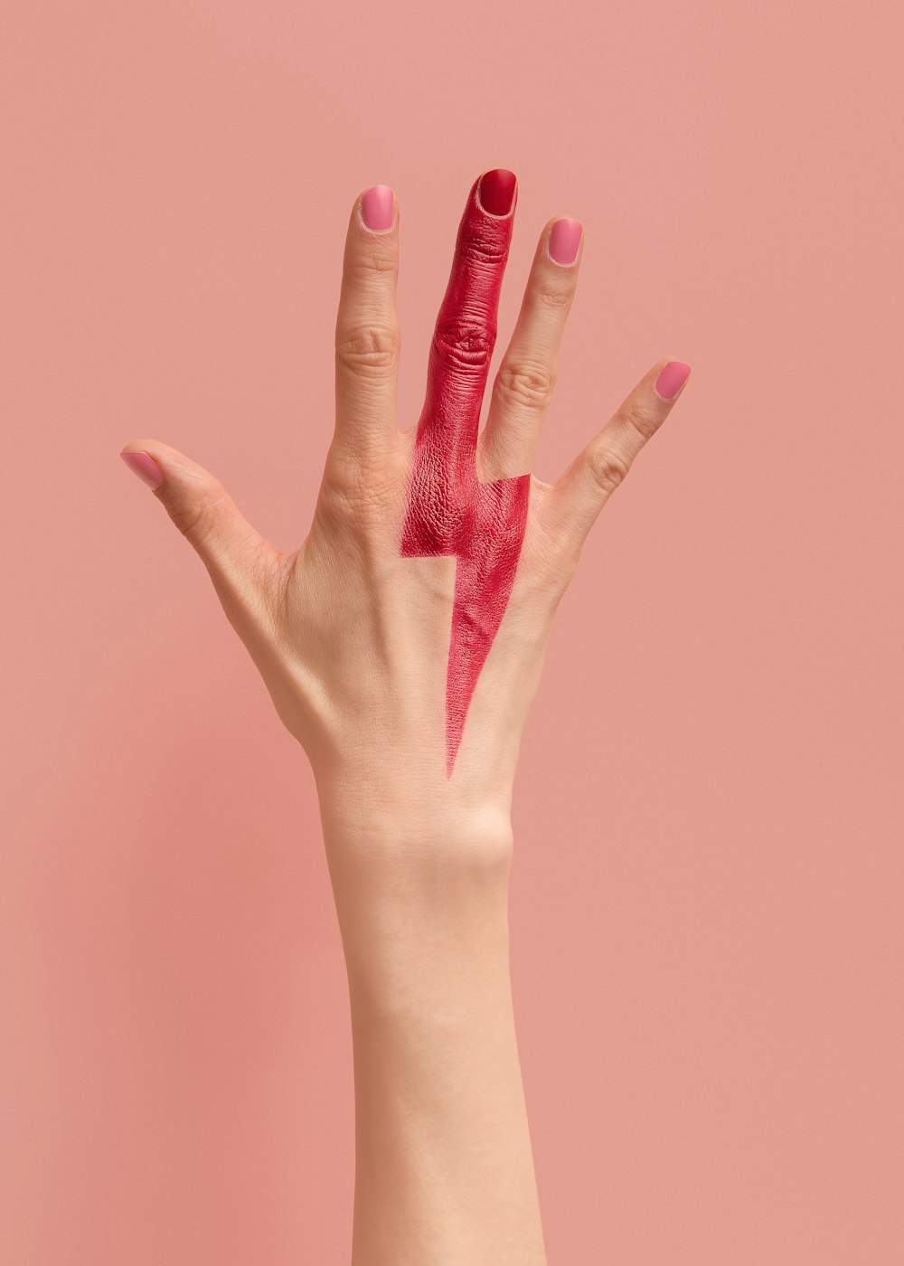 person with pink manicure on pink surface