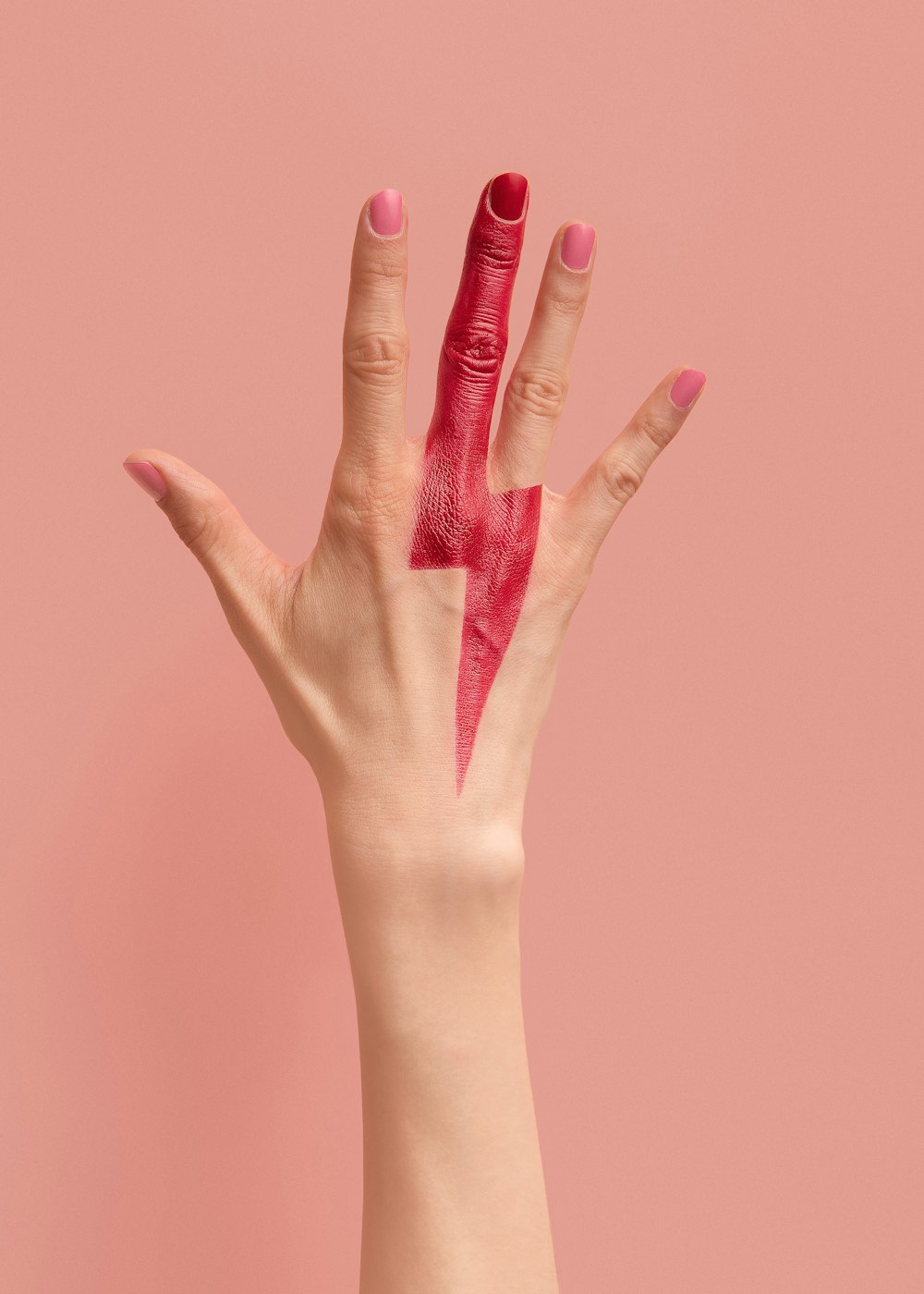 persona con manicure rosa su superficie rosa