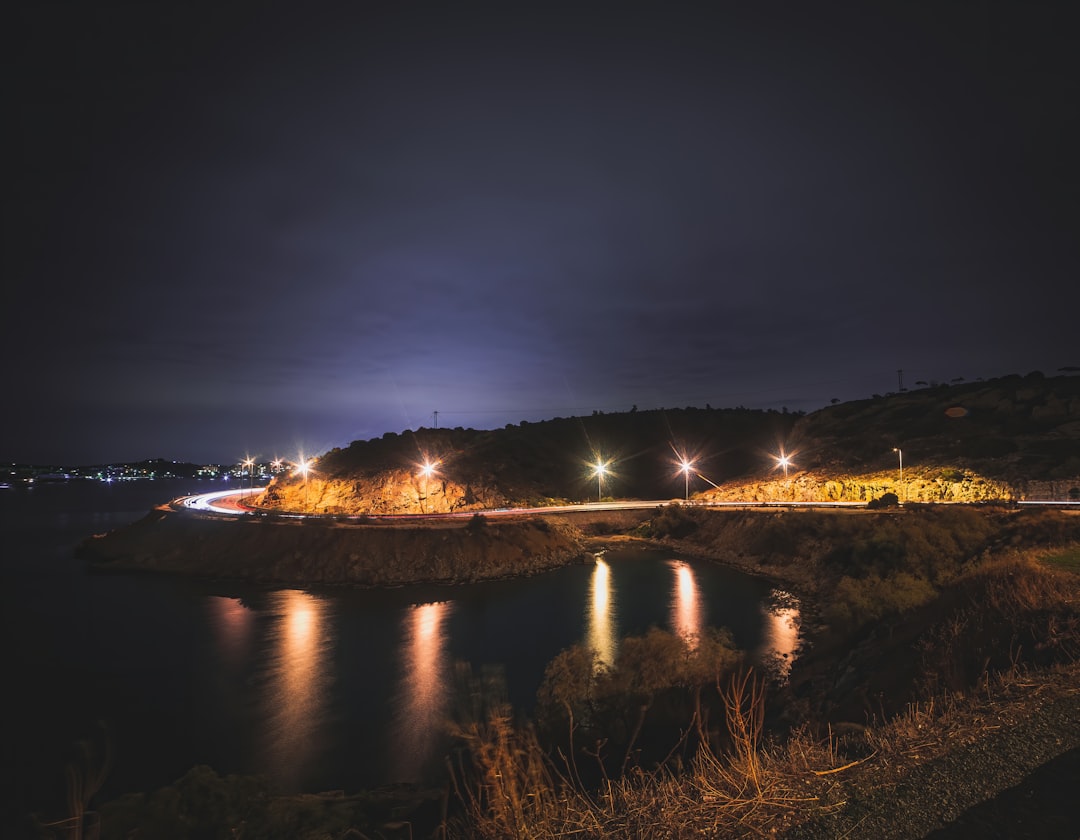 body of water between green grass field during night time