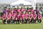 group of people in pink and black shirts on green grass field