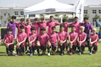 group of people in pink and black shirts on green grass field