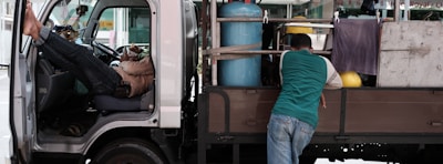 Close-up of a driver checking cargo straps inside a truck.