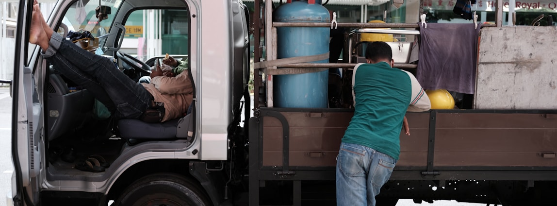 A group of lorry drivers chatting and laughing together during a break at a roadside rest area.