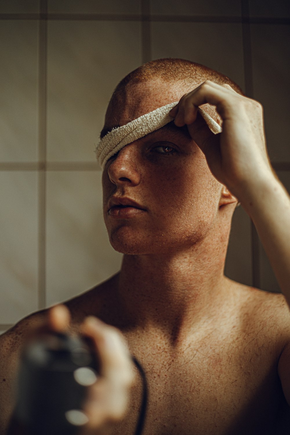 a man with a bandage around his head holding a hair dryer