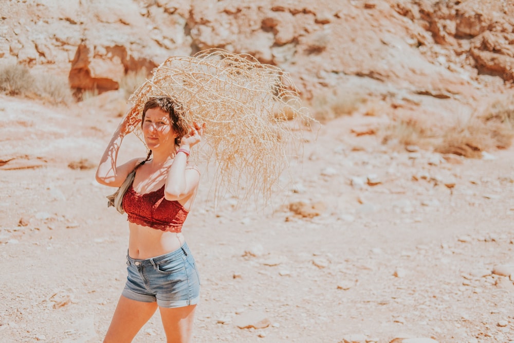 woman in blue denim shorts standing on white sand during daytime