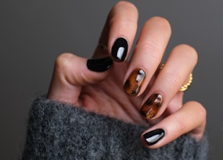 person wearing gold ring holding black textile