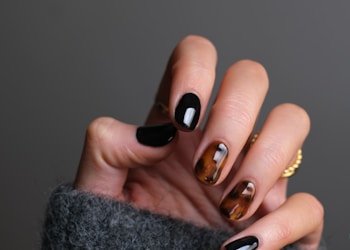 person wearing gold ring holding black textile