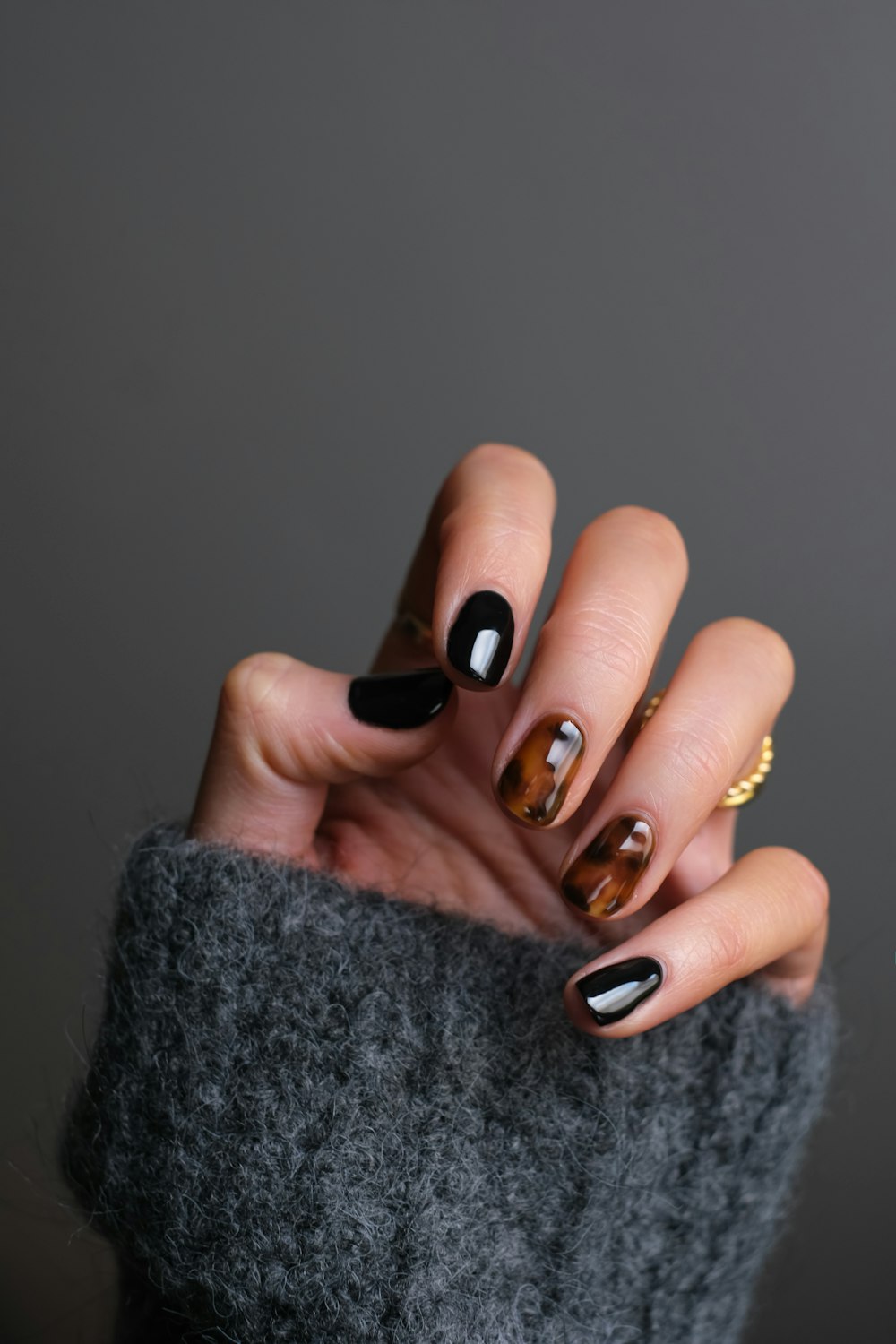 person wearing gold ring holding black textile