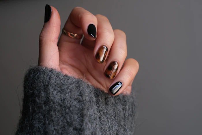 Sleek black manicure with silver ring