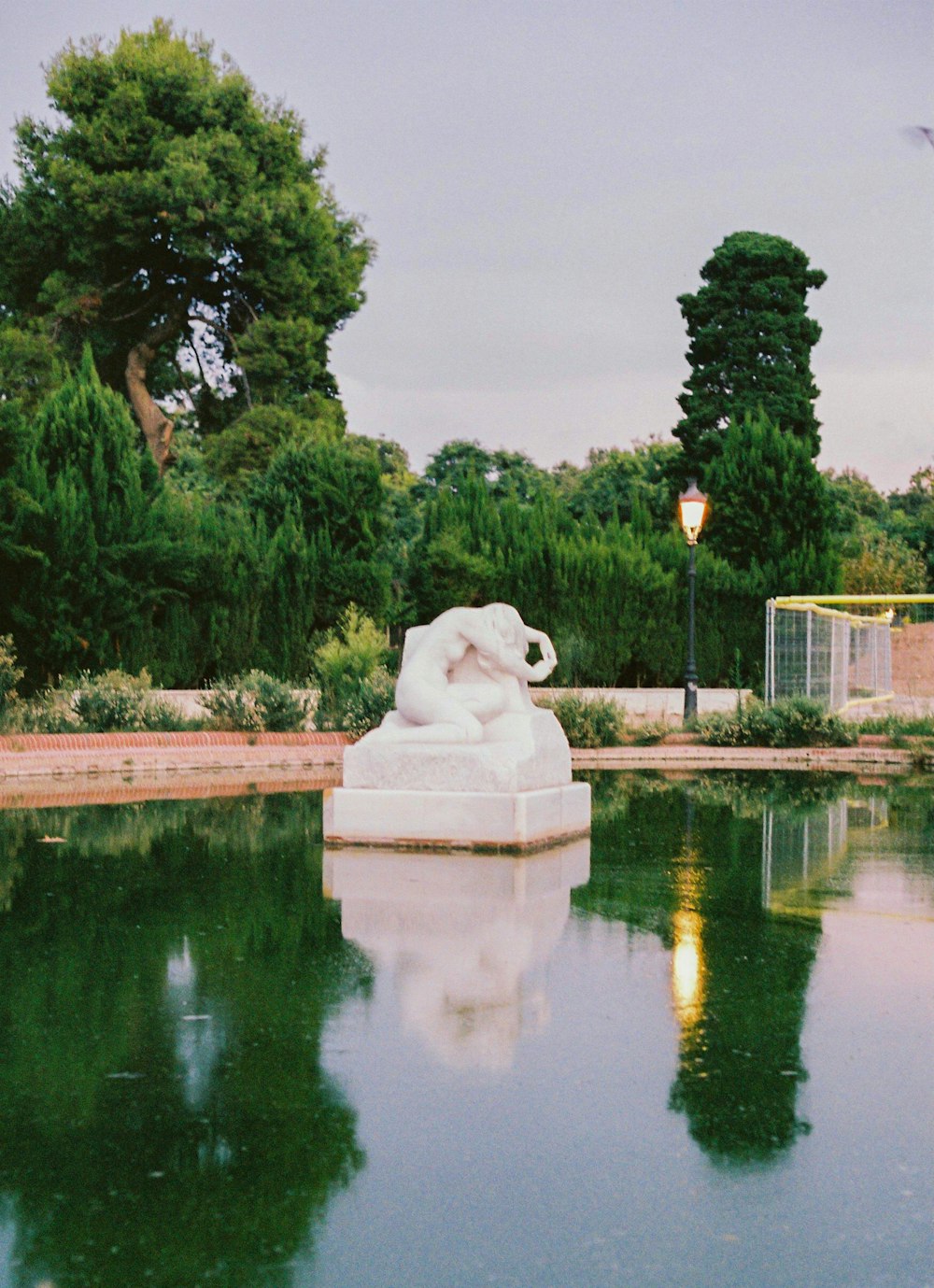 estatua de perro blanco cerca del cuerpo de agua durante el día