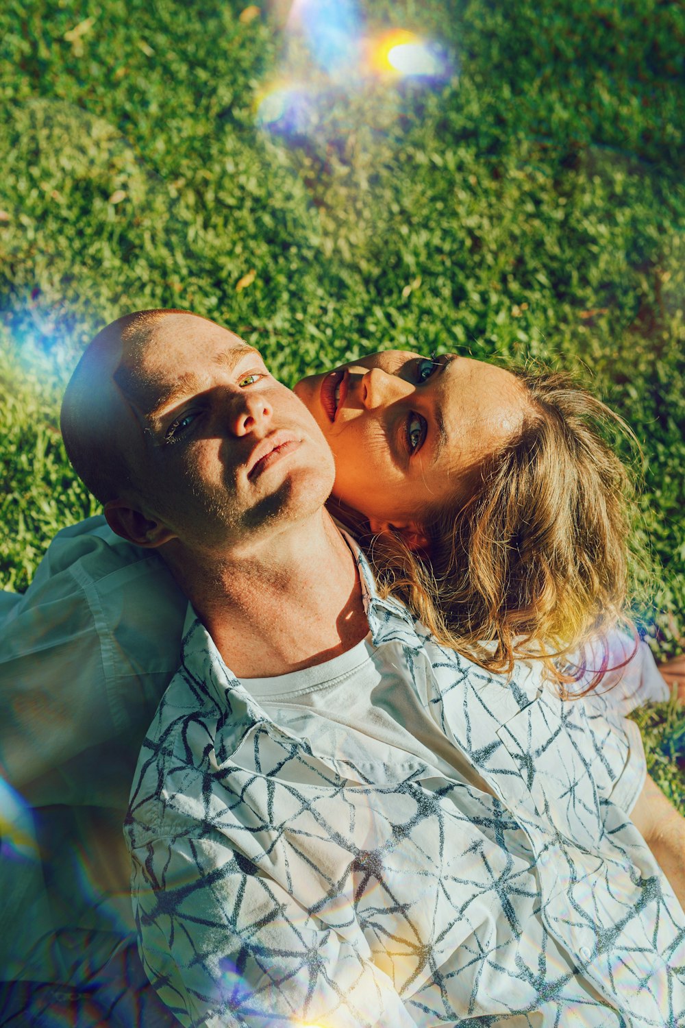a man and a woman laying in the grass