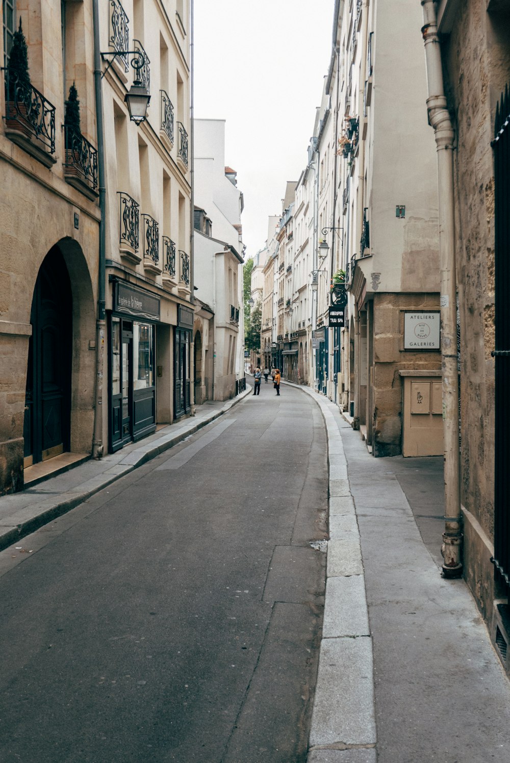 empty road between concrete buildings during daytime