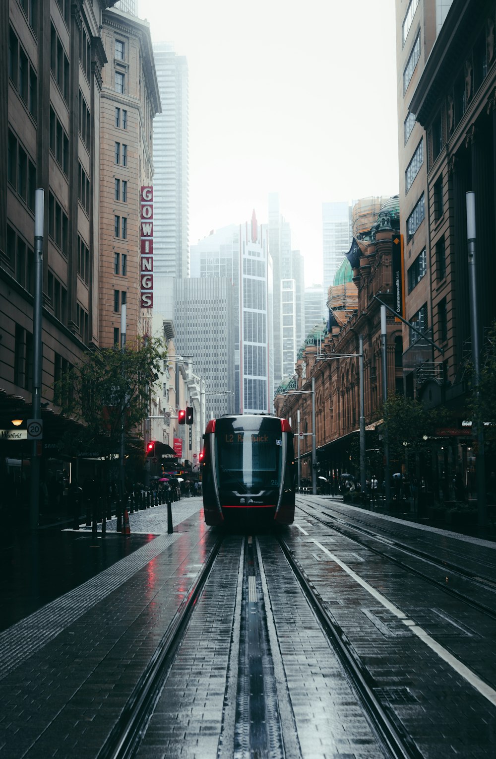 black and white train on rail road between high rise buildings during daytime