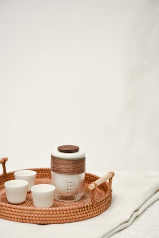 An inviting teakwood tray with recycled glass cups arranged neatly, highlighting sustainable lifestyle.
