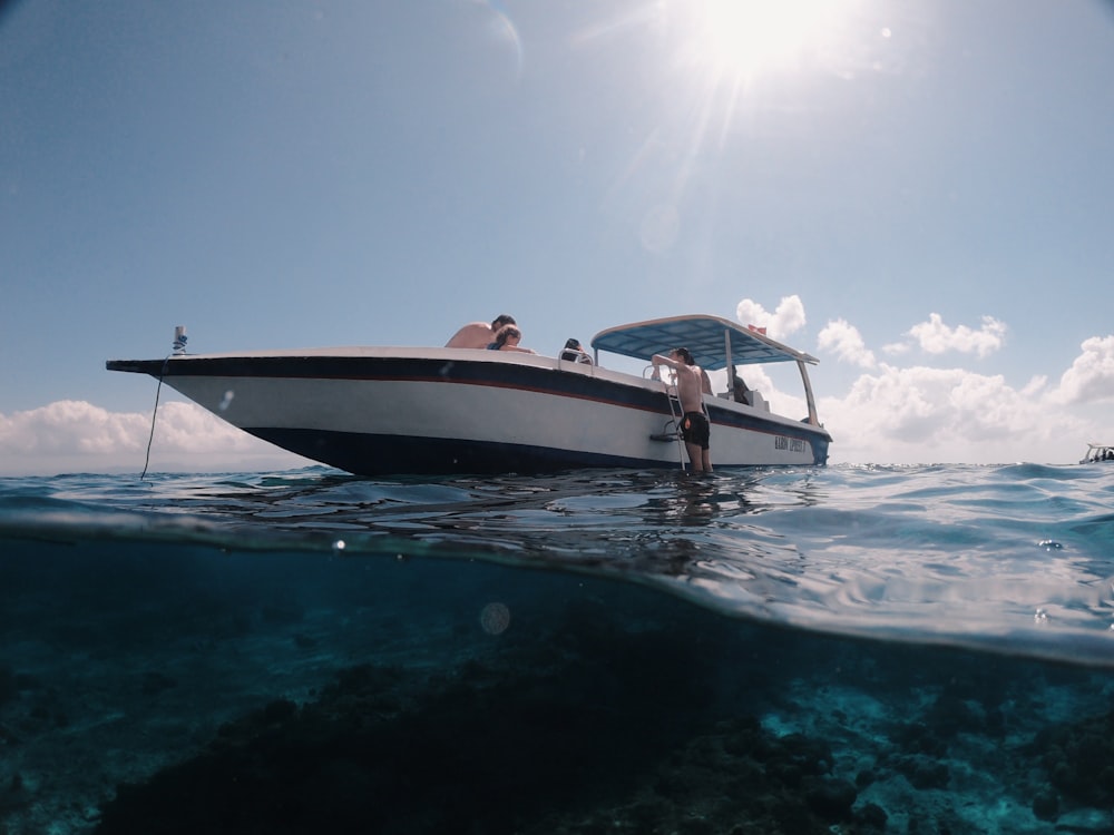 white and black boat on sea under blue sky during daytime