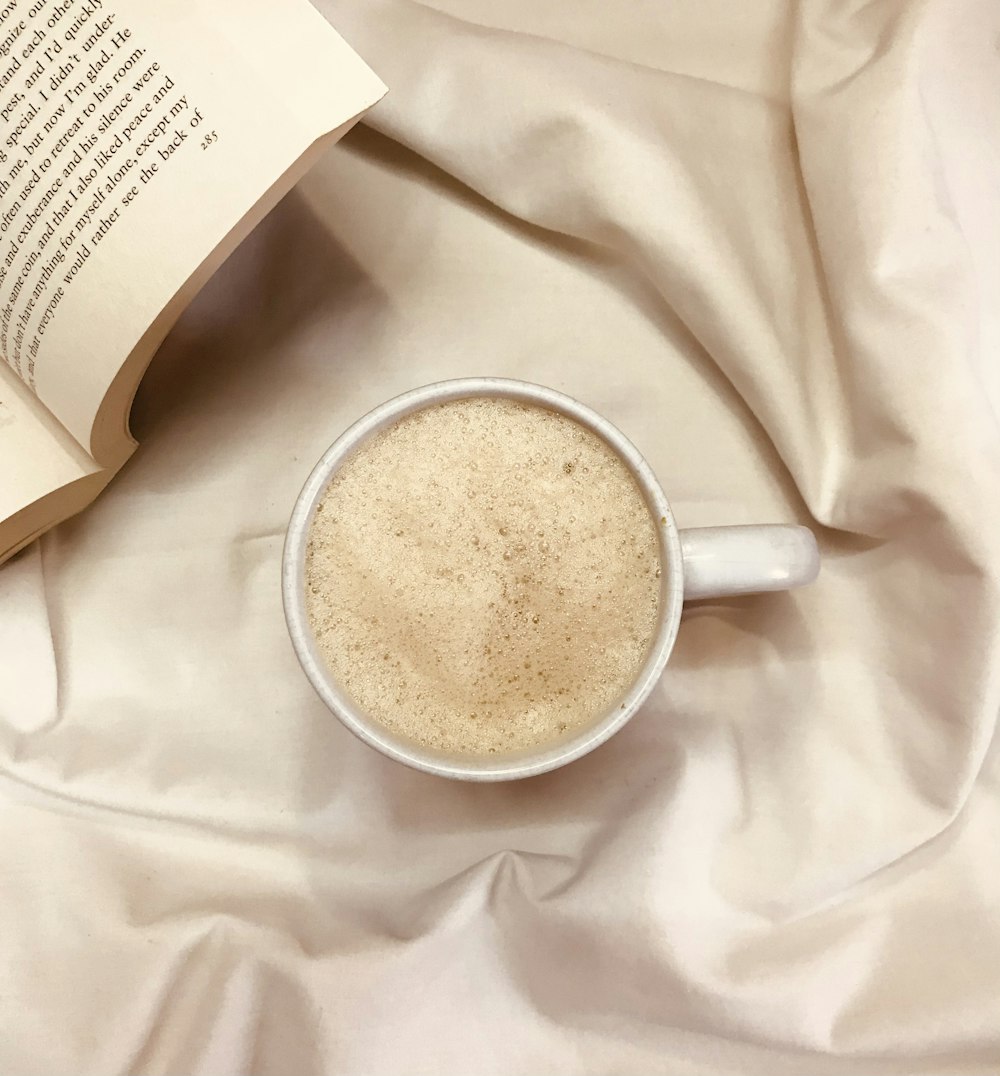 white ceramic mug on white textile