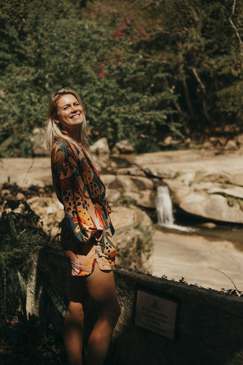 woman in black and orange long sleeve shirt and black shorts standing on brown concrete pavement