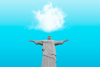 woman in beige dress raising her hands under blue sky and white clouds during daytime