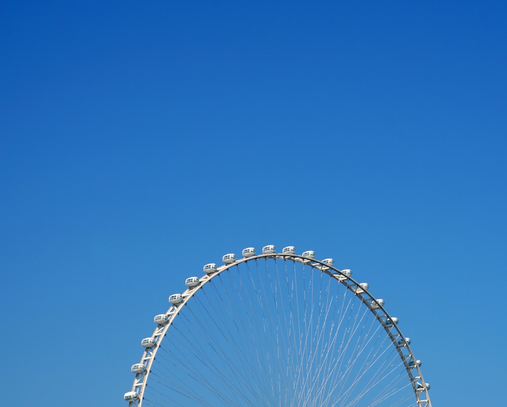 ruota panoramica bianca sotto il cielo blu durante il giorno