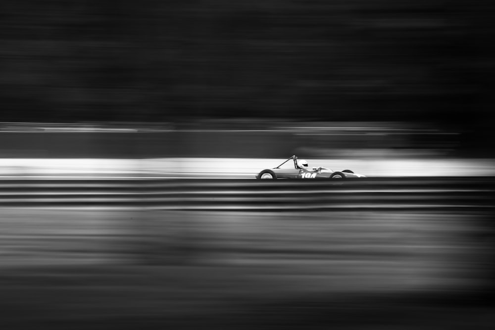 grayscale photo of sports car on road