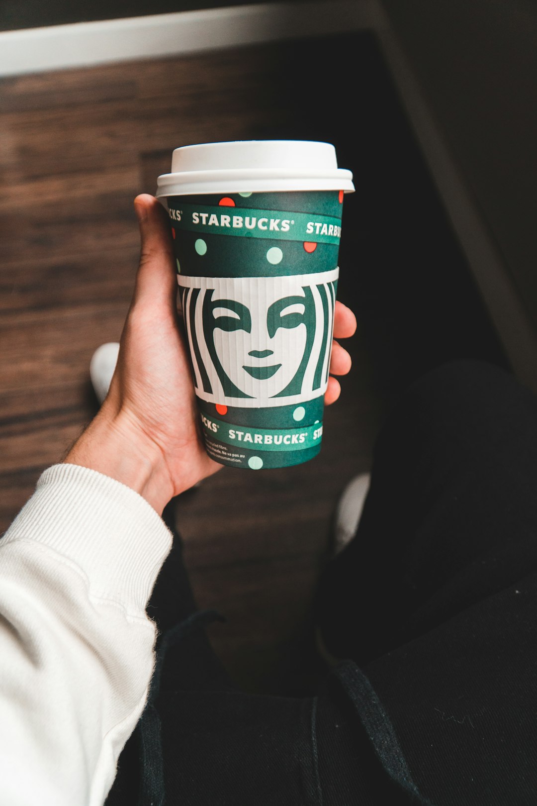 person holding green and white plastic cup