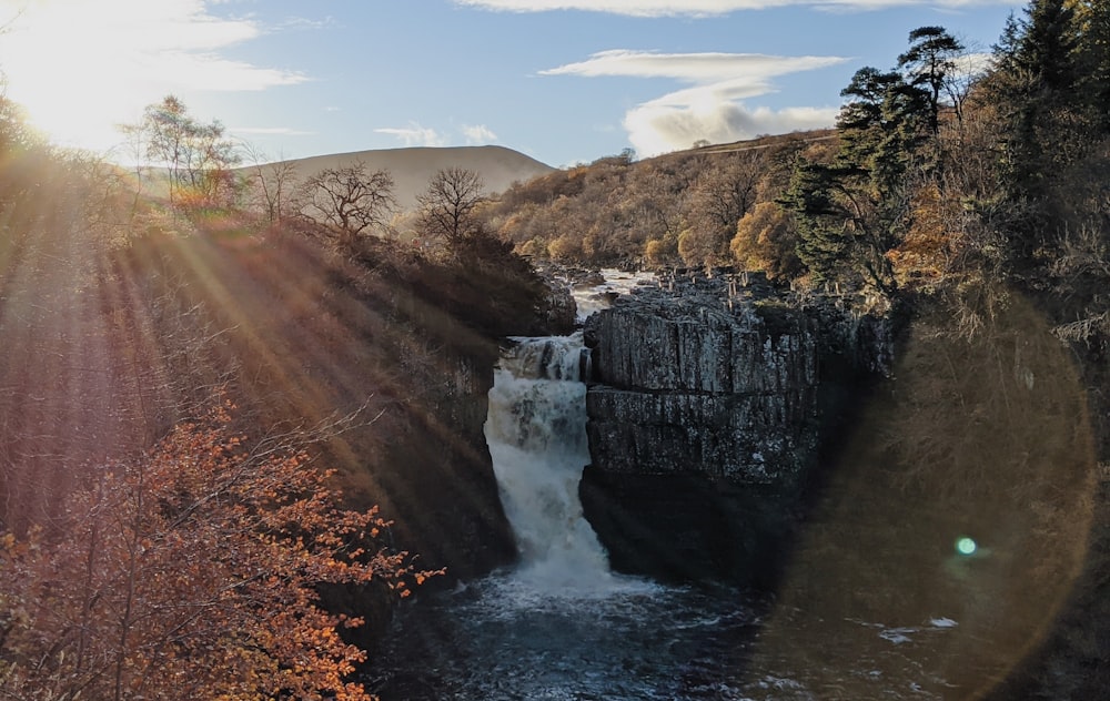 water falls between brown grass field during daytime