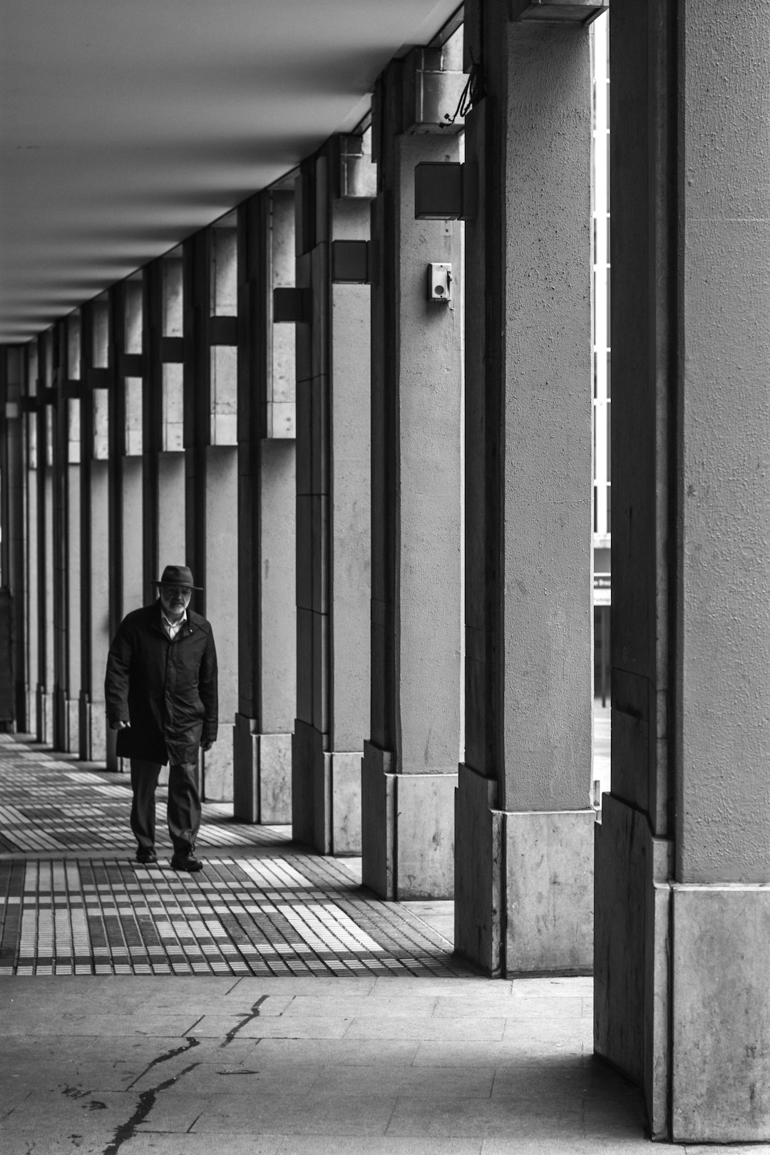 man in black coat walking on sidewalk