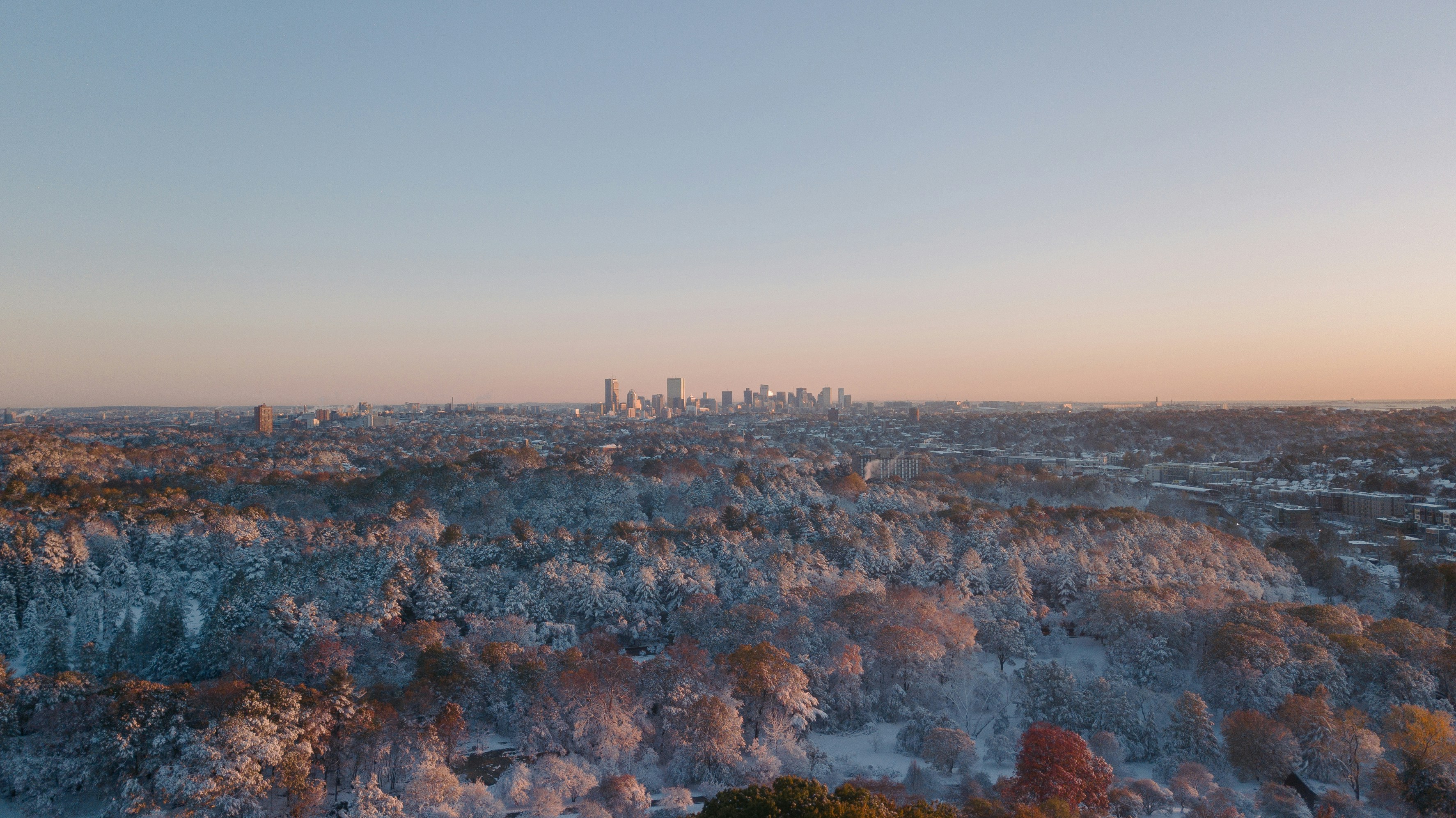 The sun rises over the Boston skyline after the first snowfall of the year.