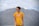 man in blue crew neck t-shirt standing near mountain under white clouds during daytime