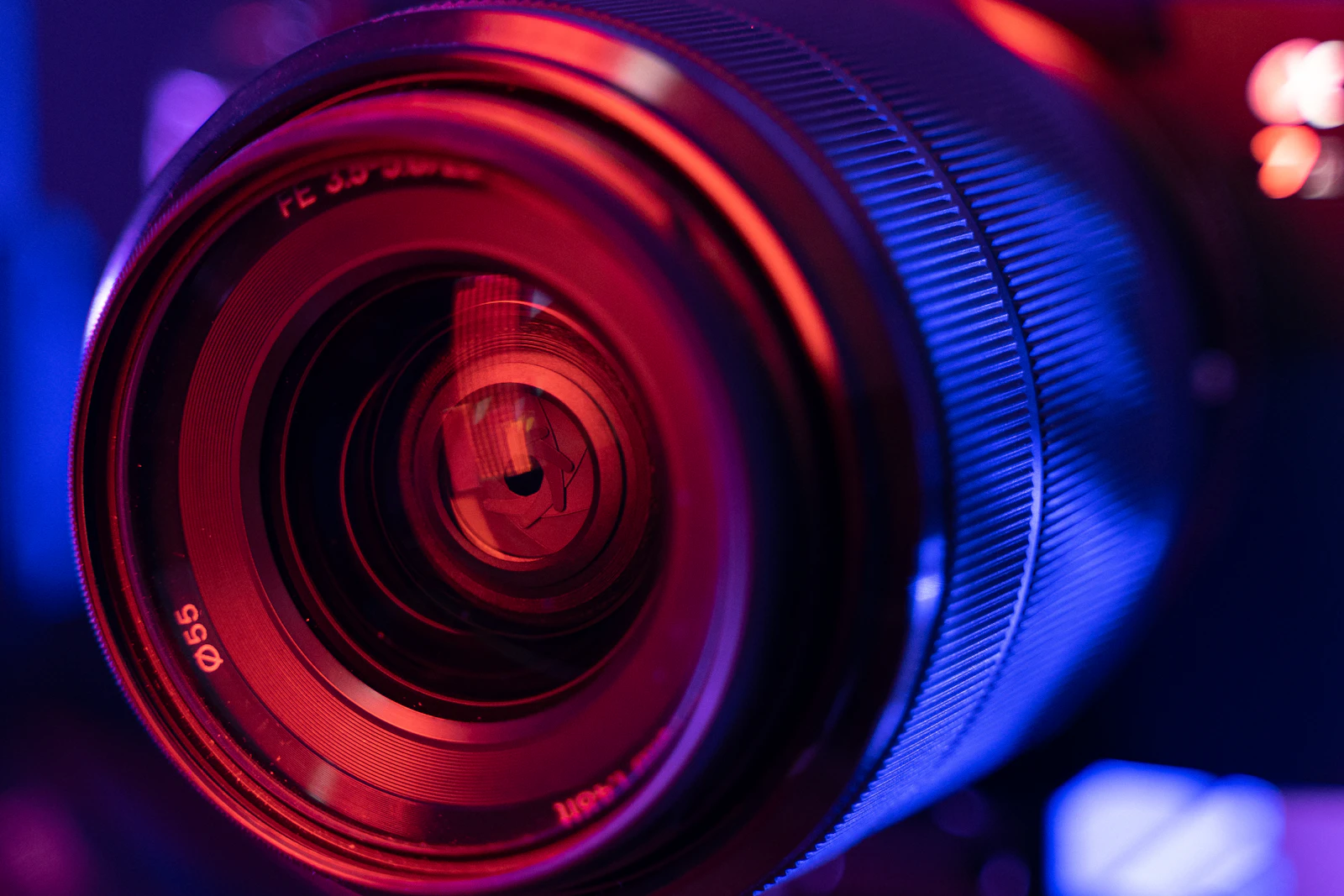 A camera lens lit red and blue, close up