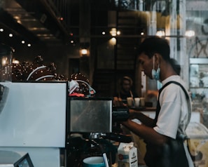 Technician performing maintenance on a coffee vending machine inside a hospital break room
