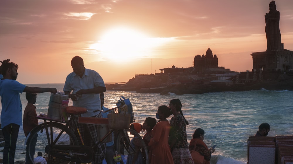 a man standing next to a bike near the ocean