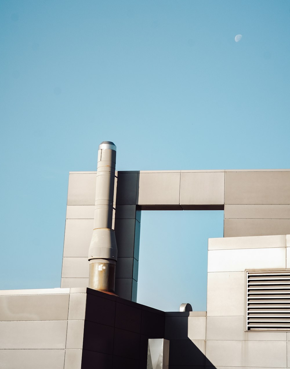 Weißes Betongebäude unter blauem Himmel tagsüber