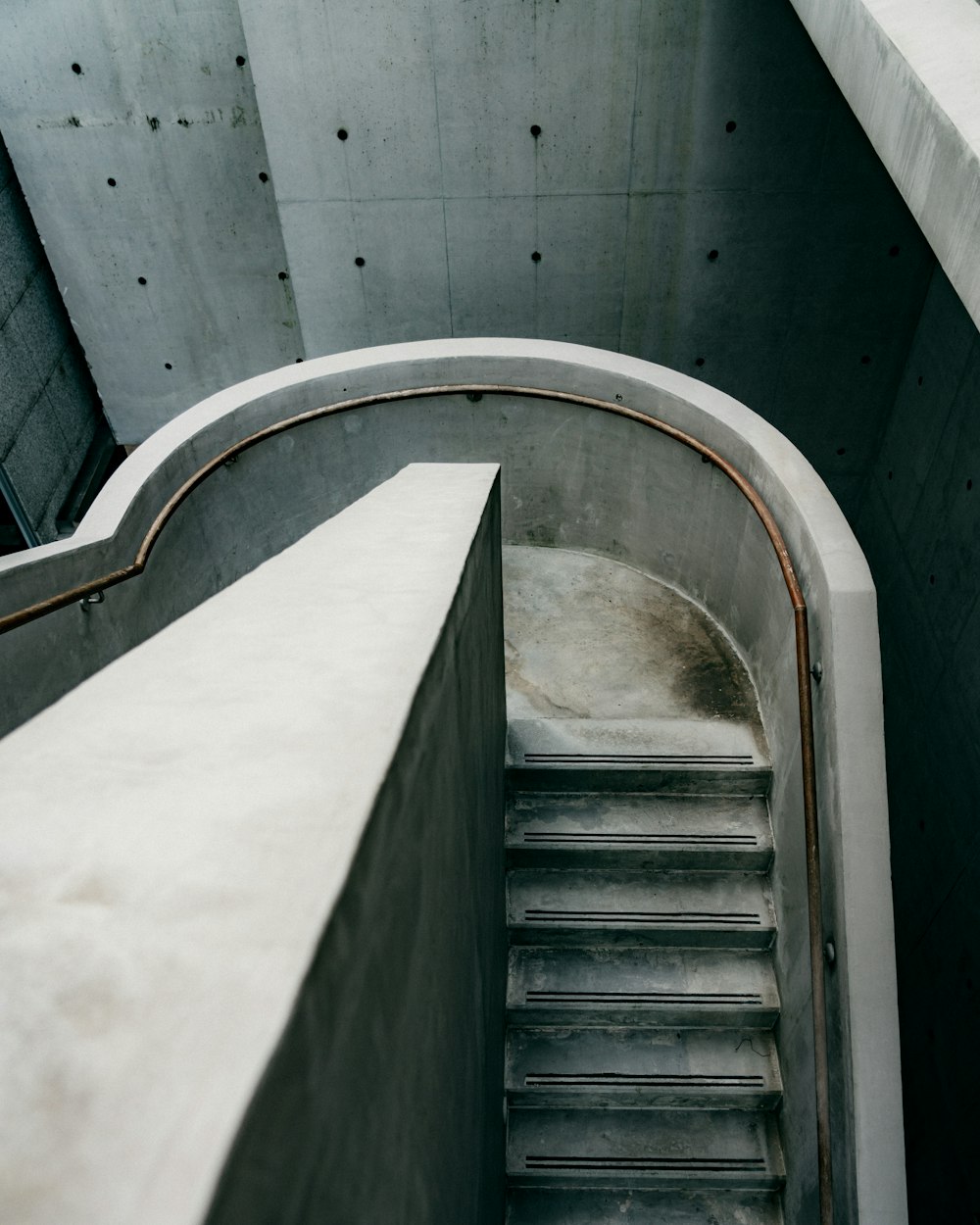 white concrete staircase with stainless steel railings