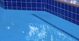blue swimming pool with black metal railings