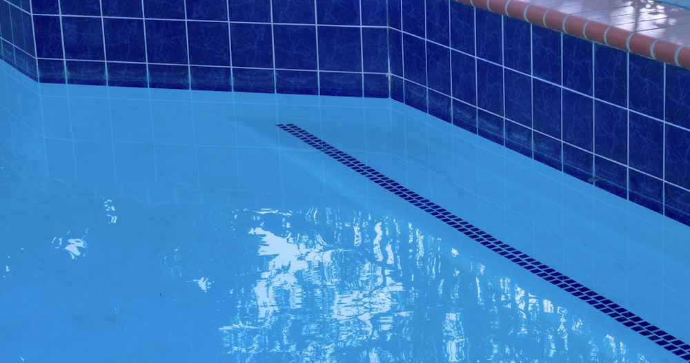 blue swimming pool with black metal railings