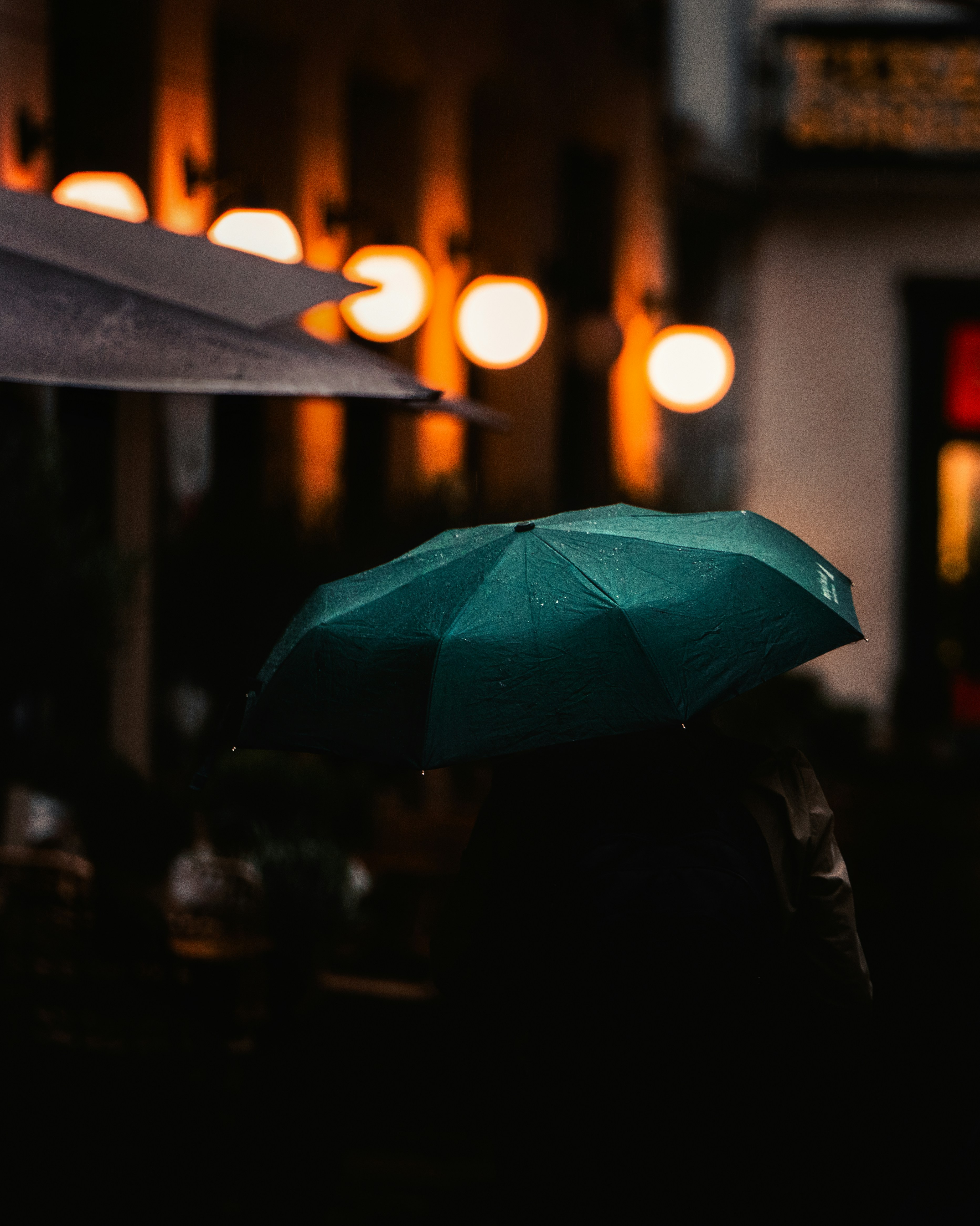 person-holding-umbrella-during-night-time